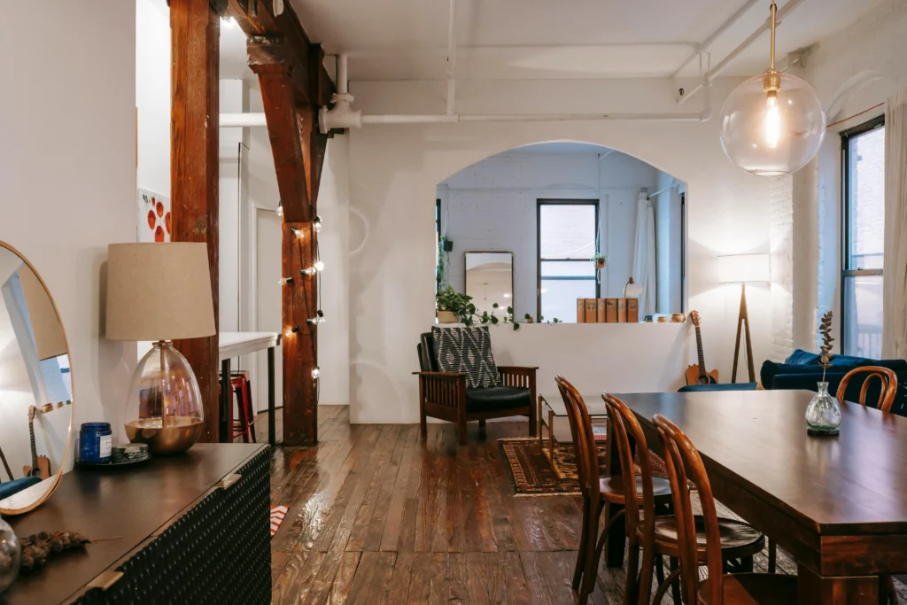 7 Claves del Pantone 2026, Cloud Dancer Comedor loft con vigas de madera y lámpara de globo