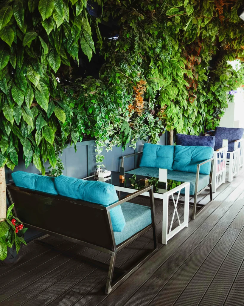 “Club Fontanar” Terraza Vegetal con Sofás Azules y Envolvente de Plantas