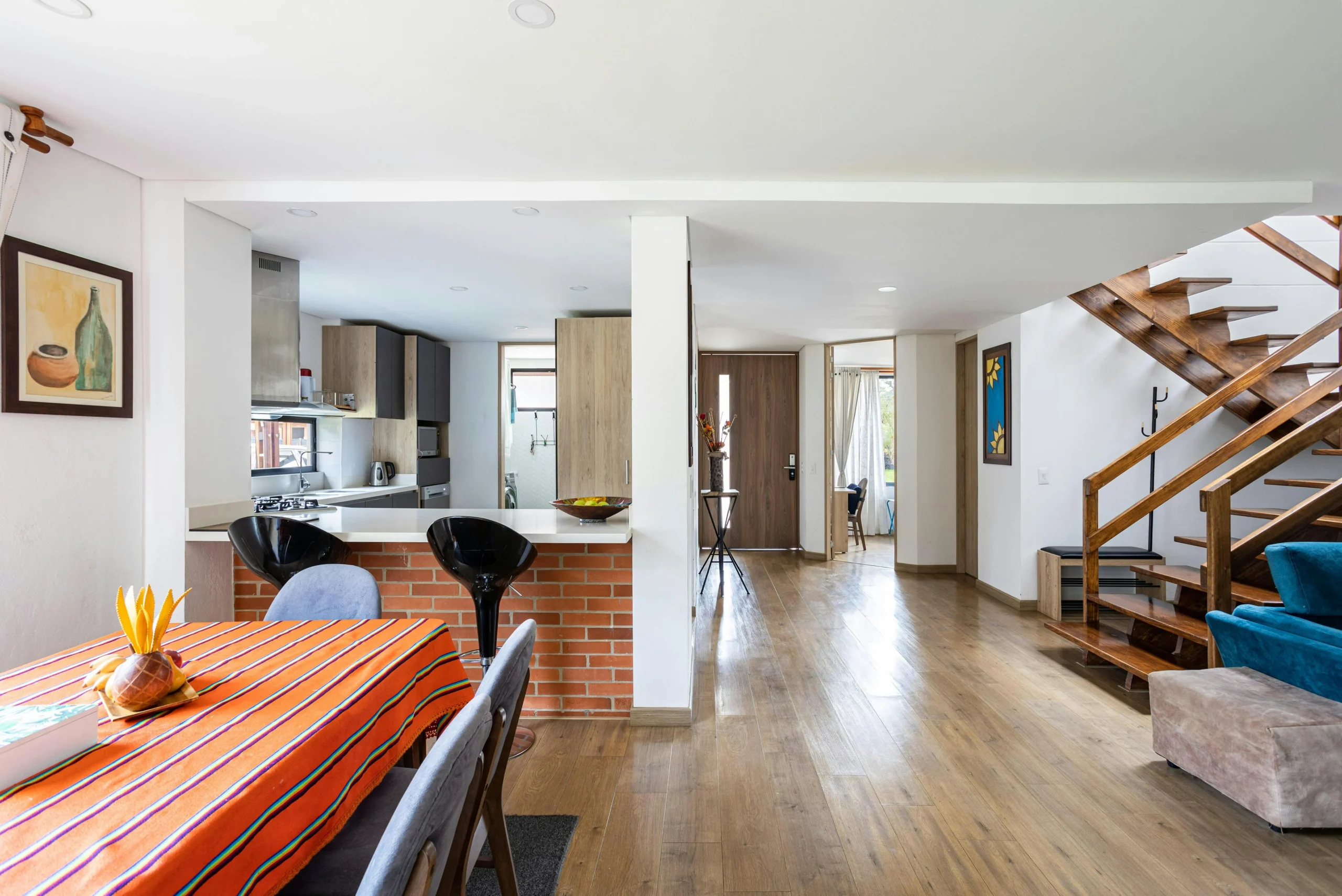 Espacio Social con Comedor Abierto y Escalera de Madera