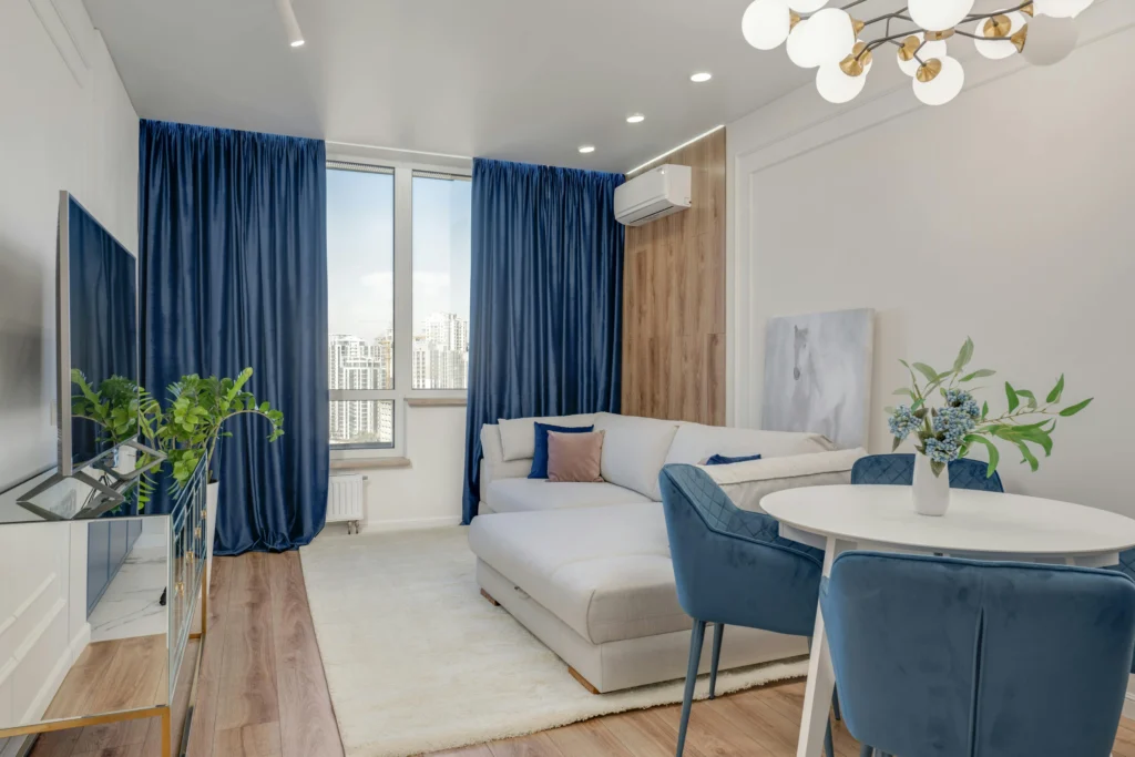 7 Claves del Pantone 2026, Cloud Dancer Sala Contemporánea con Cortinas Azul Marino y Sofá en L