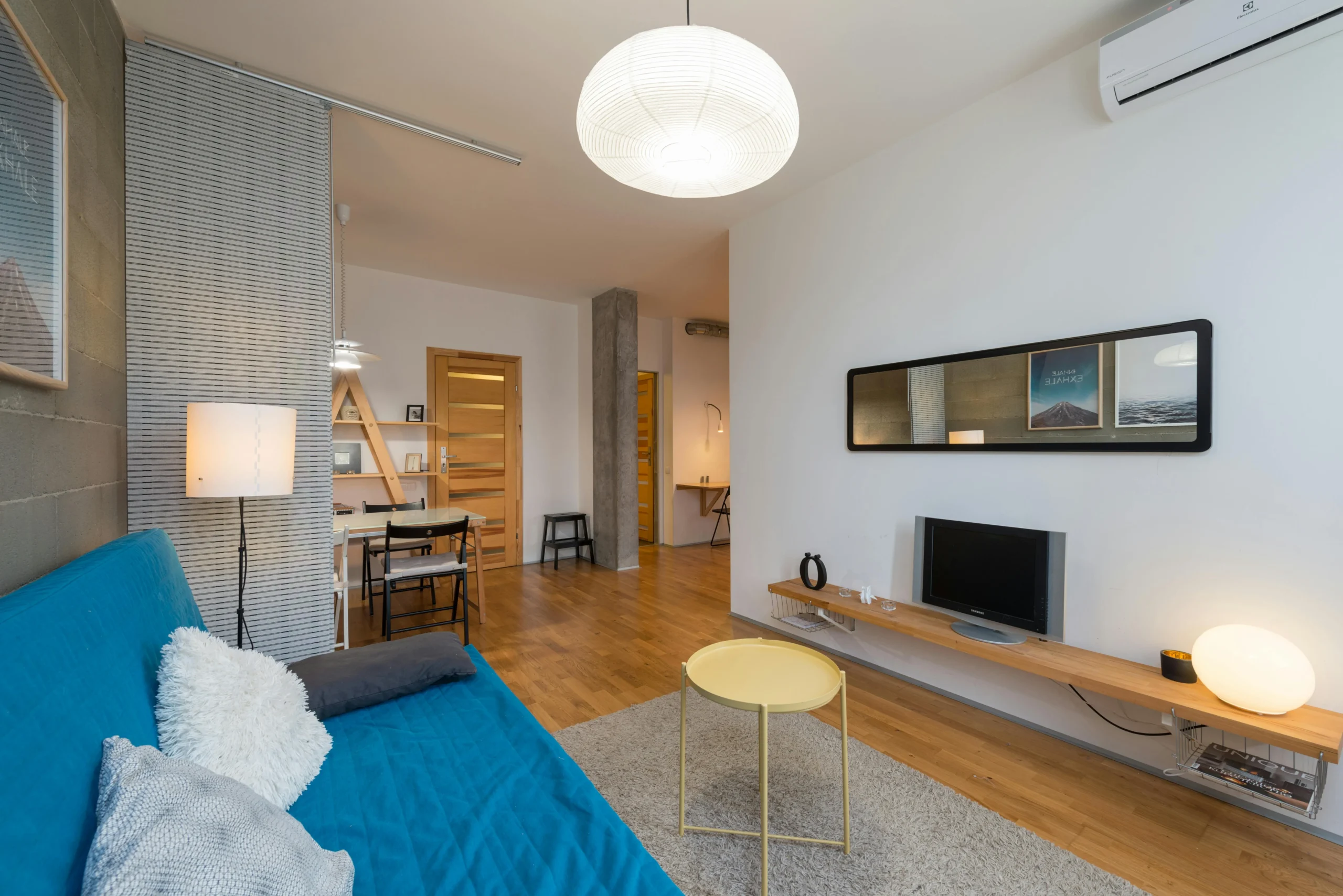 Sala Ecléctica con Sofá Azul y Toques de Madera Natural