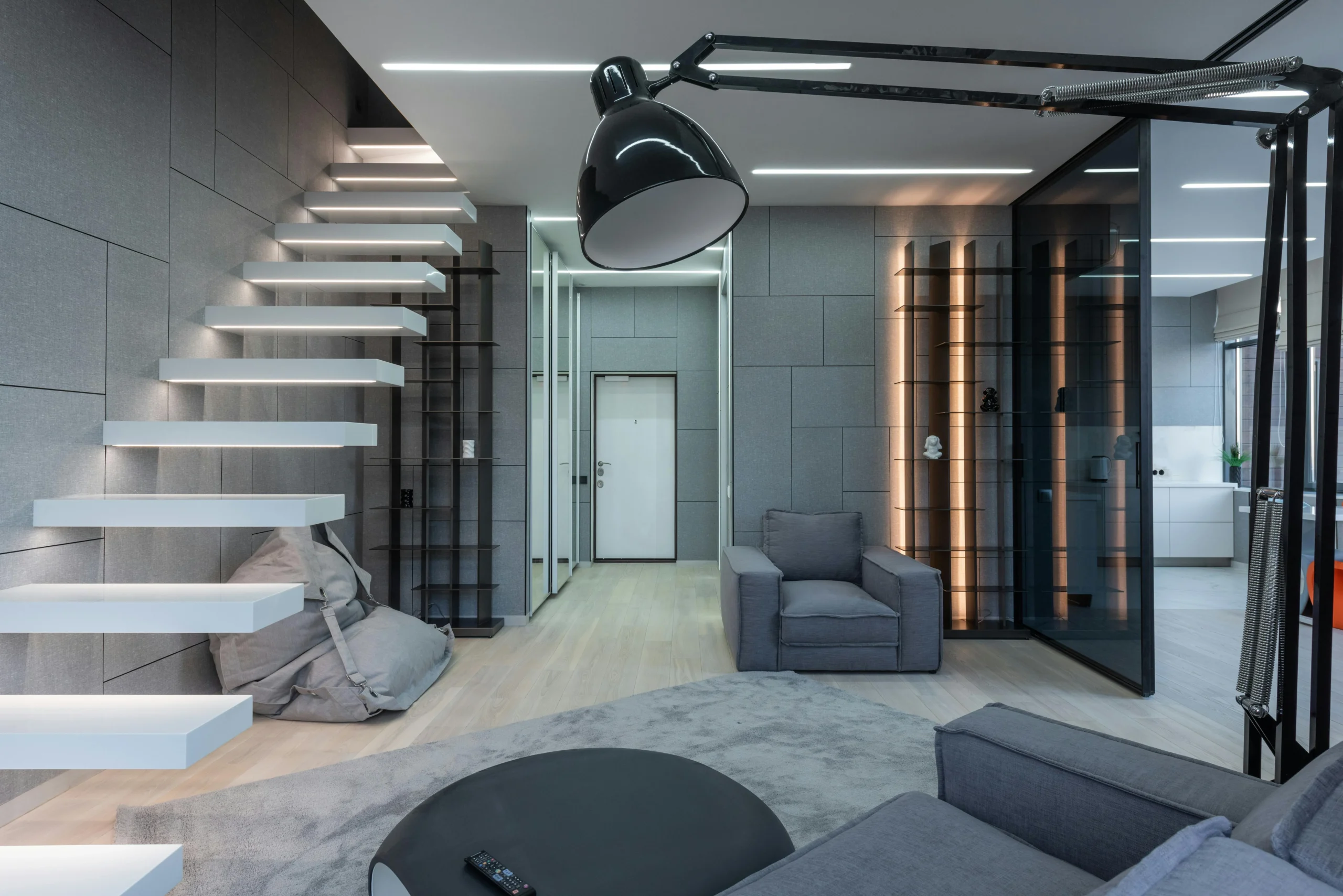 Sala Minimalista con Escalera Flotante y Acabados Grises