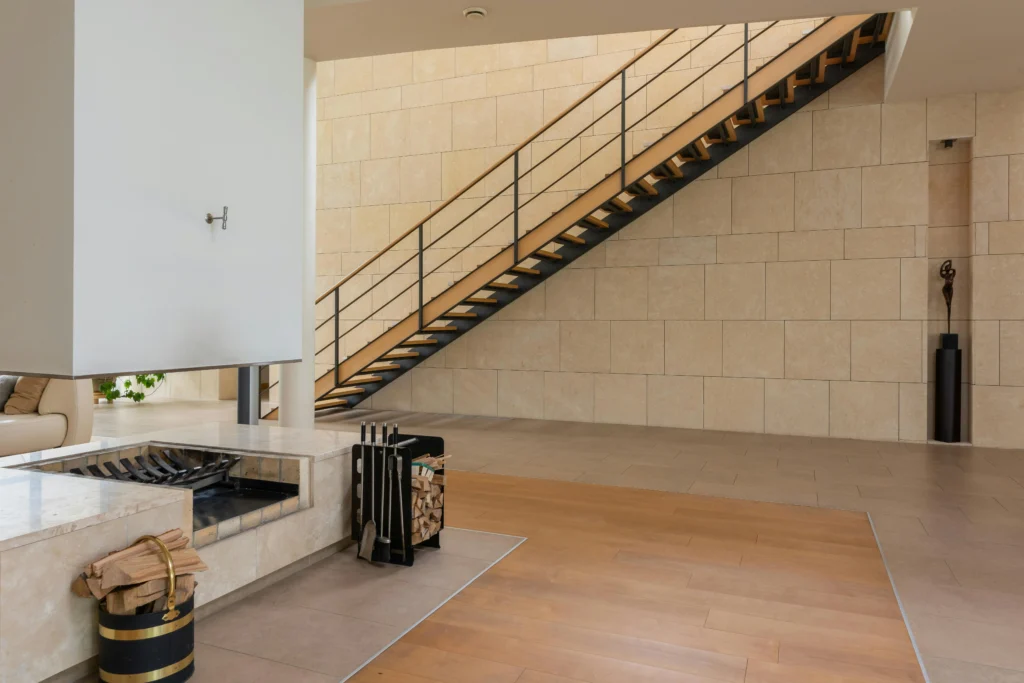 Sala de Estar con Chimenea Abierta y Escalera de Madera