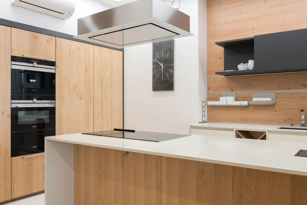 Cocina Minimalista con Isla y Panelado de Madera Clara