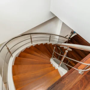 Escalera de Madera Oscura con Barandilla Metálica y Curva Elegante