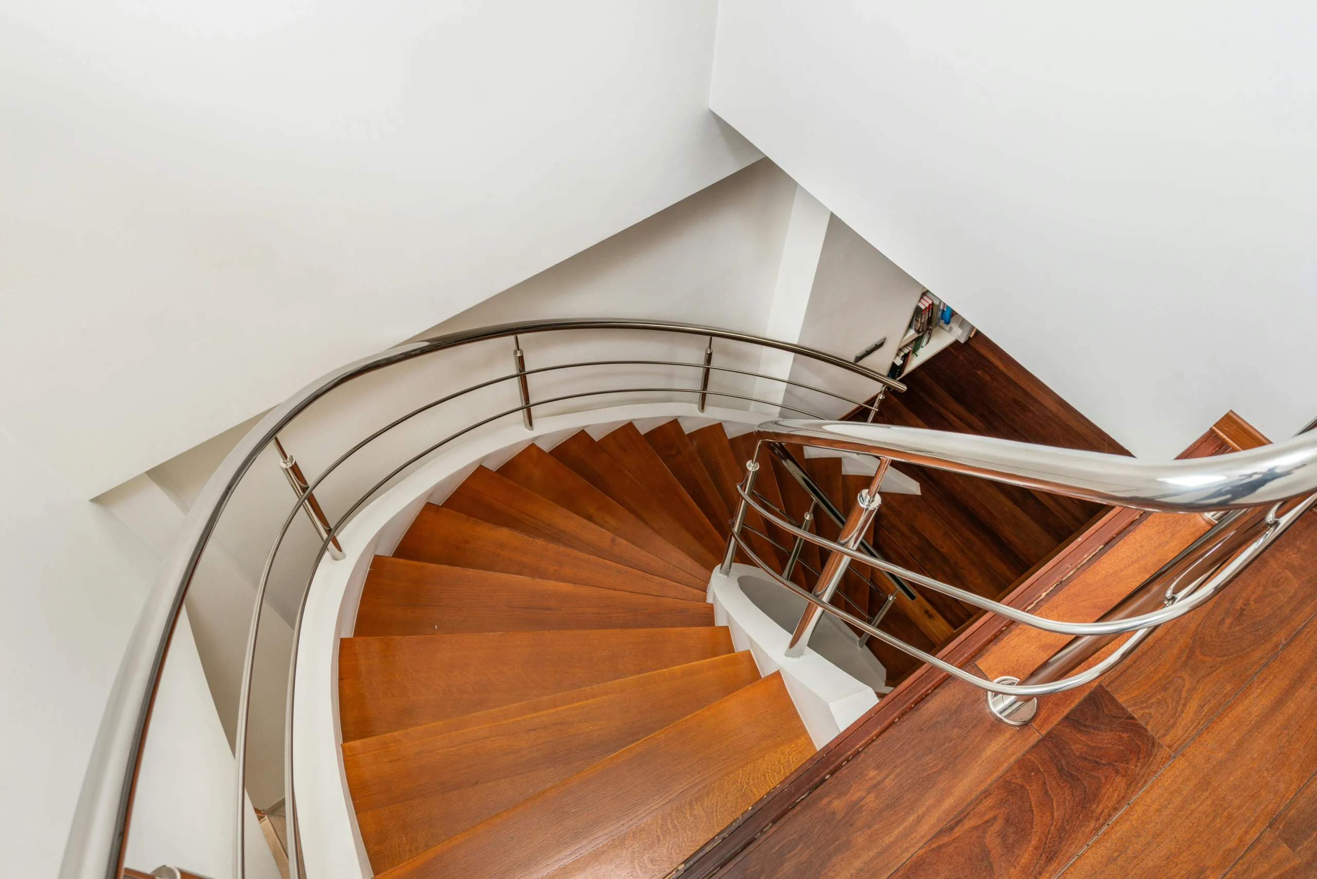 Escalera de Madera Oscura con Barandilla Metálica y Curva Elegante
