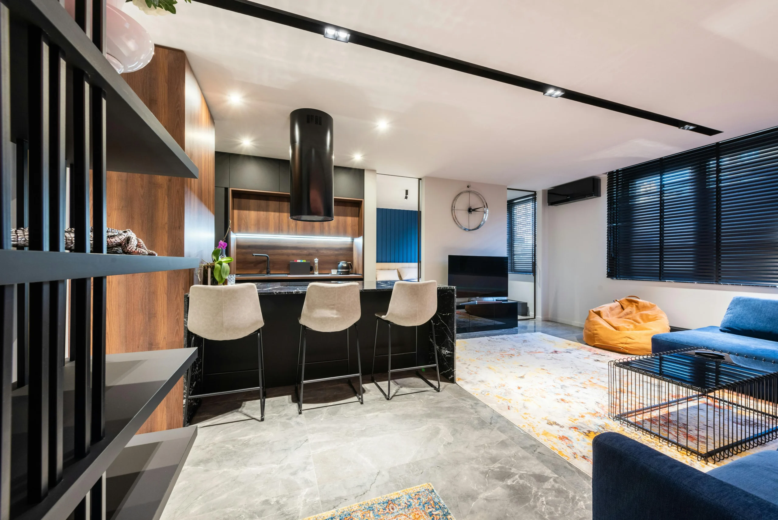 Salón-Cocina con Isla Negra y Madera Oscura en Planta Abierta