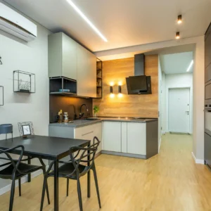 Cocina Minimalista en Gris y Negro con Panel de Madera Clara