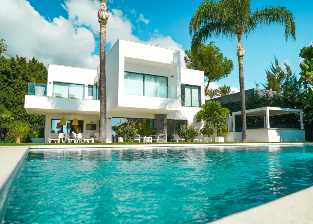 inicio Fachada blanca contemporánea con piscina y palmeras