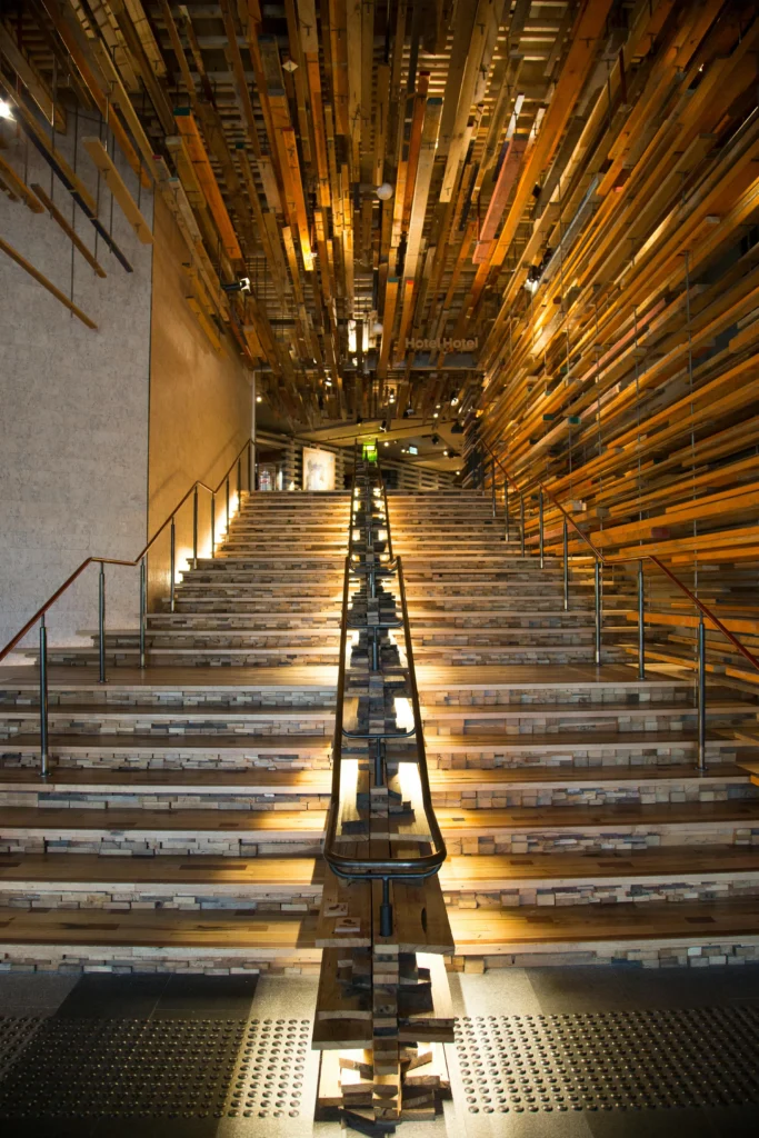 Escalera en Lobby de Impacto y Volumen con instalación en Madera Reciclada