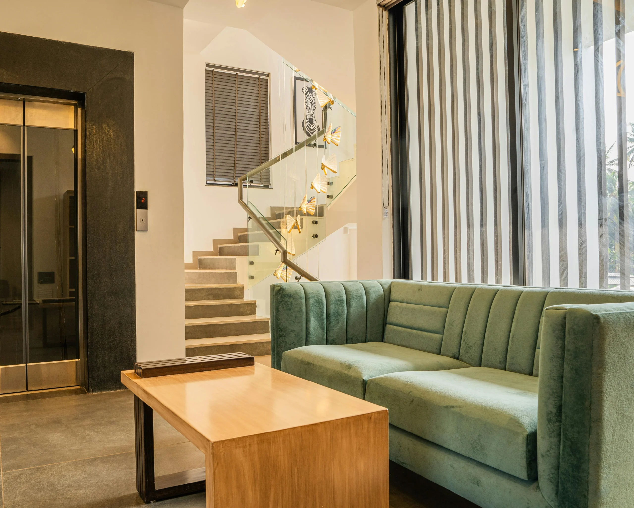 Sala de Espera Contemporánea con Sofá Verde y Mesa de Madera Natural