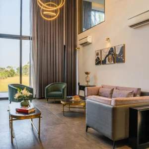 Salón de Doble Altura con Ventanales y Mobiliario de Autor