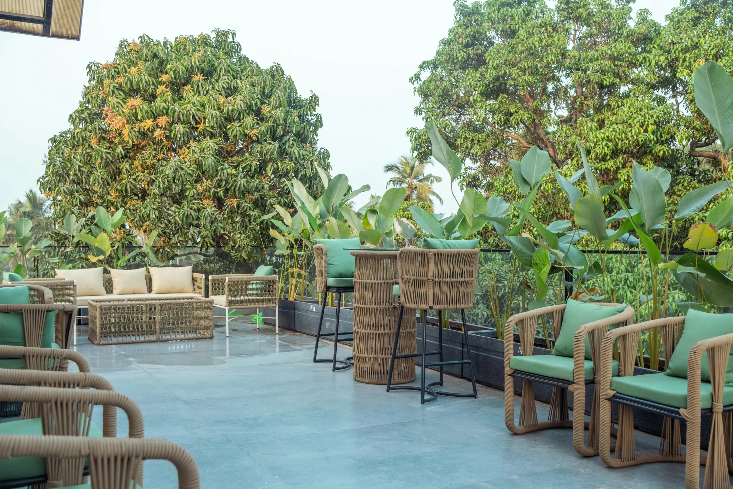 Terraza Social con Mobiliario de Cuerda y Cojines Verdes