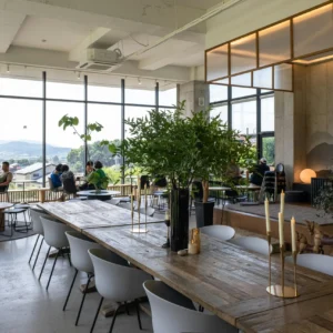 Cafetería Contemporánea con Mobiliario Natural y Luz Panorámica