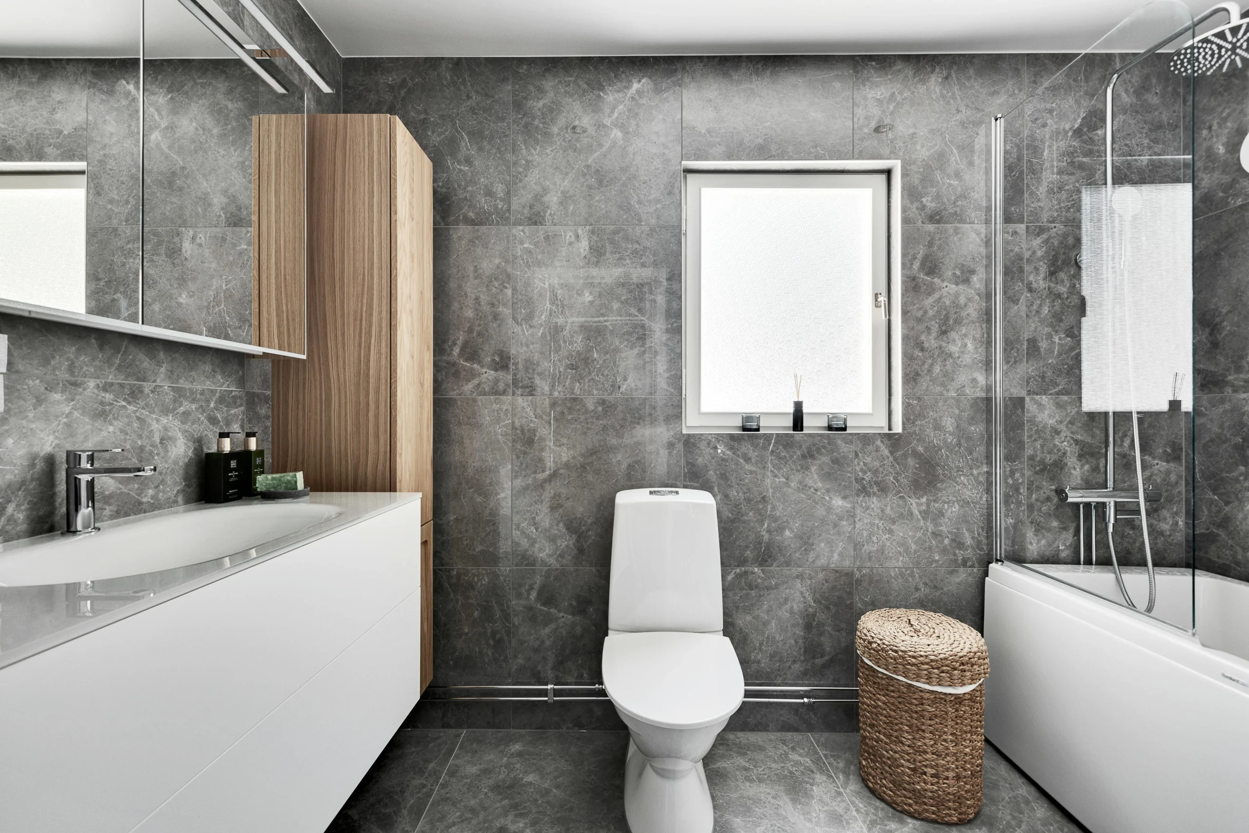 Baño Nórdico-Contemporáneo con Revestimiento de Mármol Gris y Madera Clara