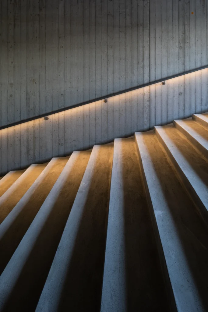 inicio Escalera de concreto con iluminación indirecta en pasamanos