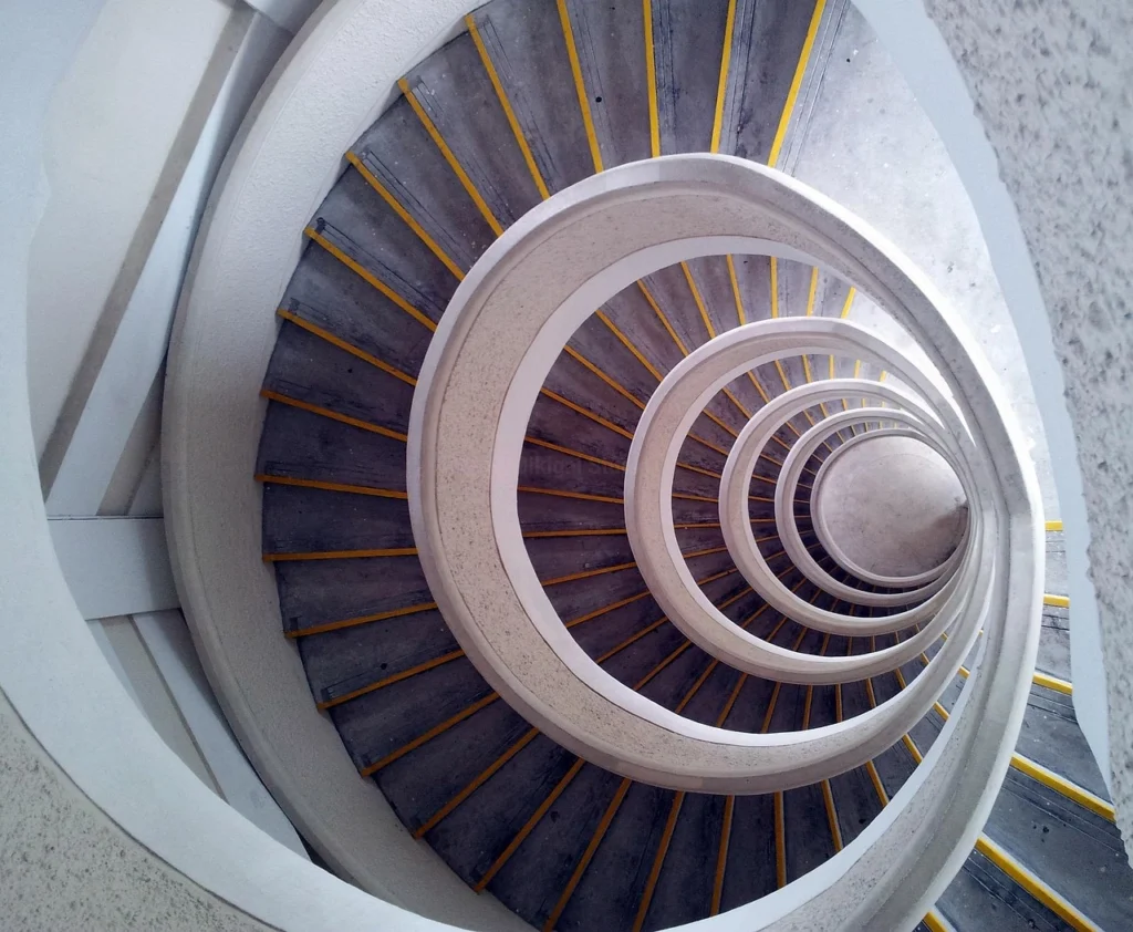 Escalera helicoidal en concreto con franjas amarillas