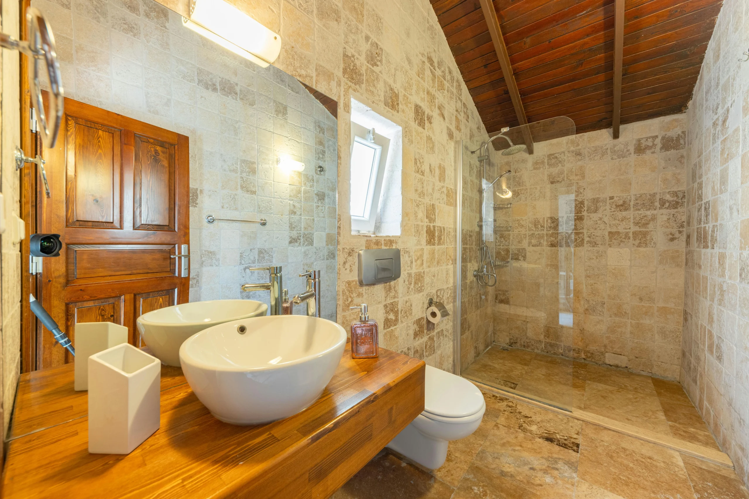 Baño Rústico-Mediterráneo con Piedra Natural y Techo de Madera