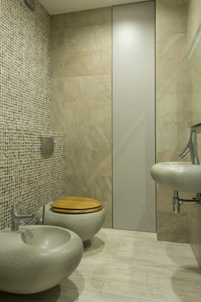 Baño con Piedra Natural con Sanitarios de Autor y Pared de Mosaico