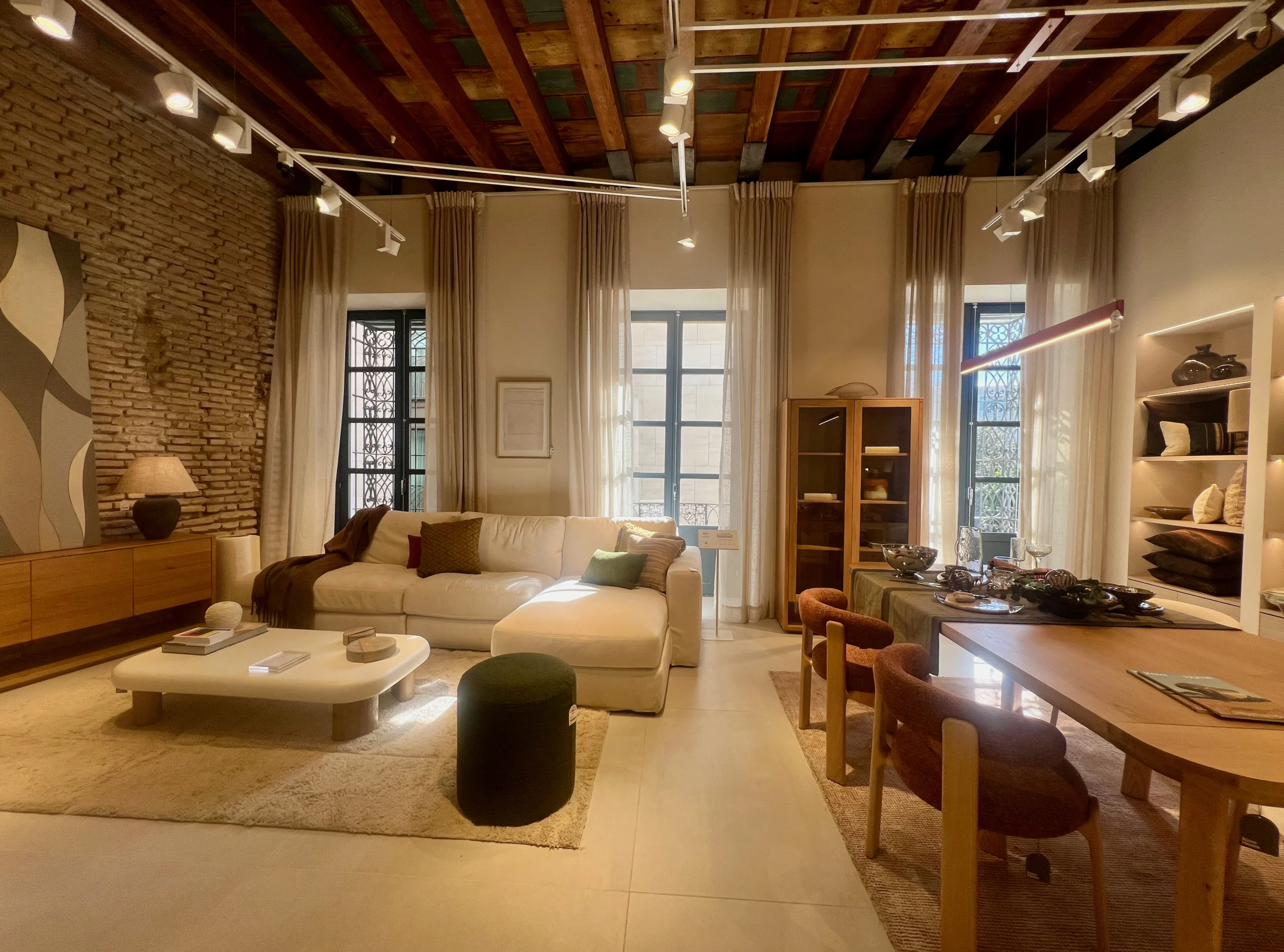 Salón-Comedor Estilo Loft con Pared de Ladrillo Visto y Vigas de Madera