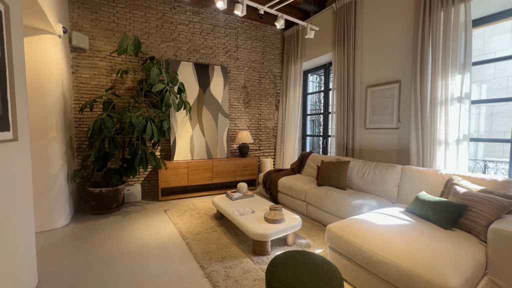 Salón Rústico-Contemporáneo con Sofá Chaise-Longue y Muro de Ladrillo