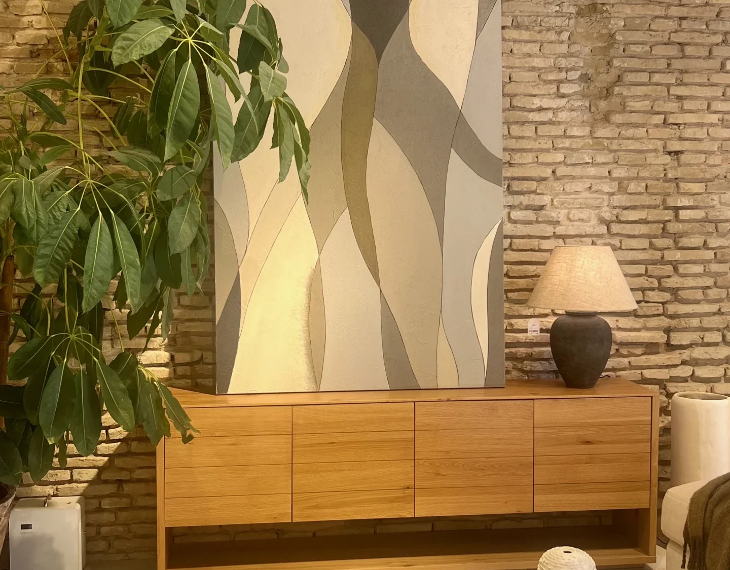 Salón Rústico-Contemporáneo con Aparador de Madera y Muro de Ladrillo Visto