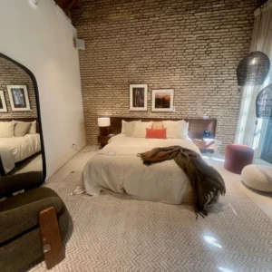 Suite Estilo Loft con Pared de Ladrillo Visto y Mobiliario de Madera Oscura