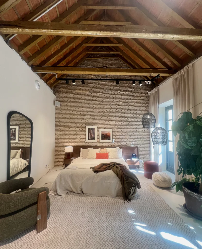 inicio Suite Principal Estilo Loft con Techo de Vigas y Pared de Ladrillo Visto