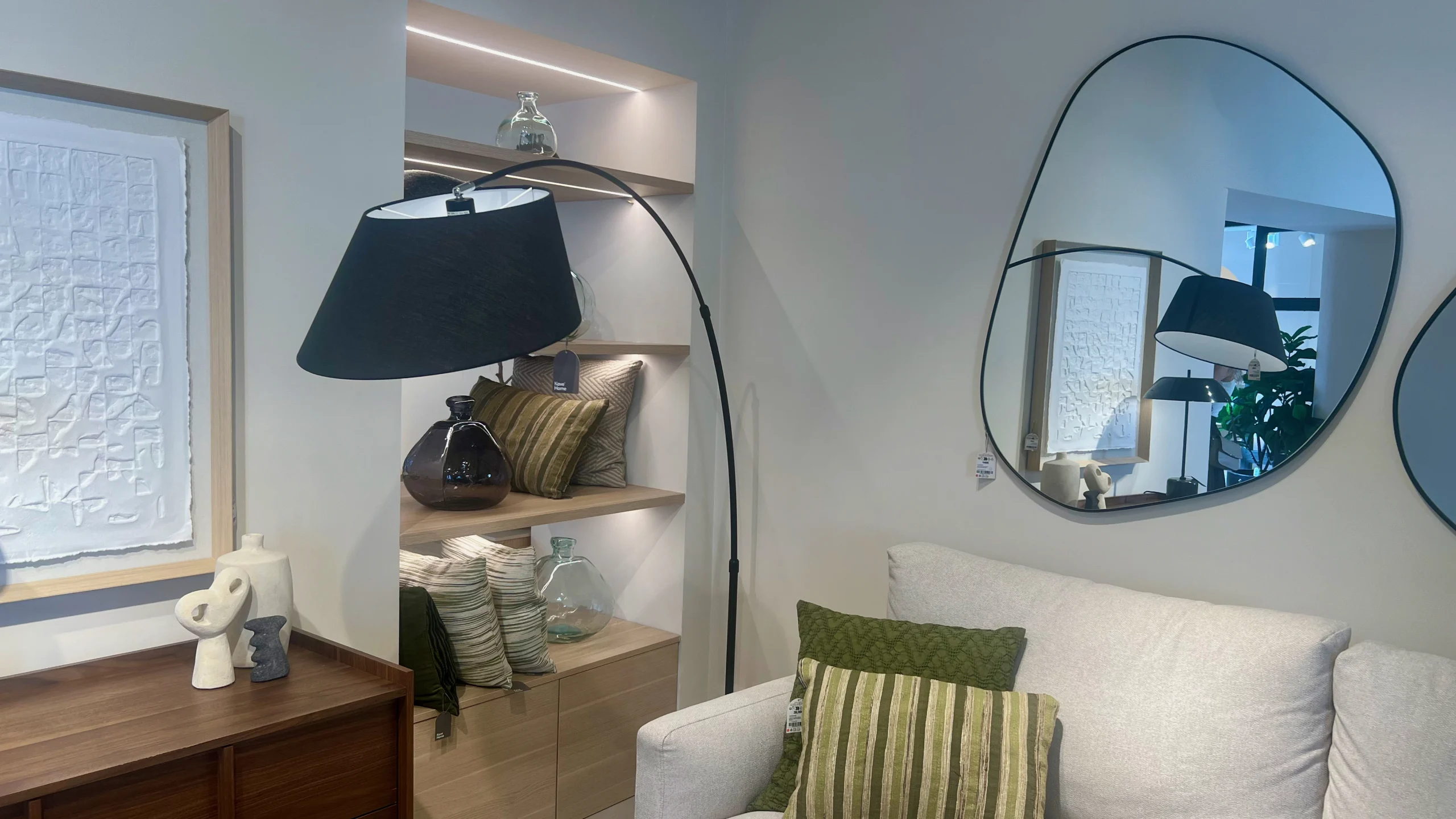 Salón Ecléctico con Sofá Neutro, Aparador Oscuro y Espejos Orgánicos