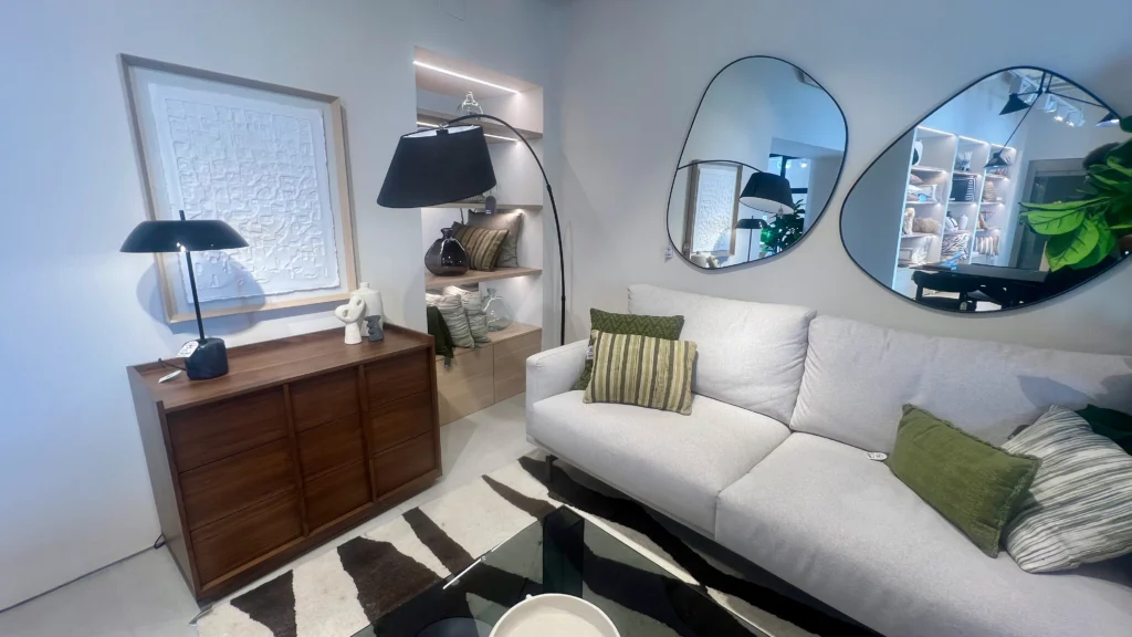 Salón Ecléctico con Sofá Neutro, Aparador Oscuro y Espejos Orgánicos